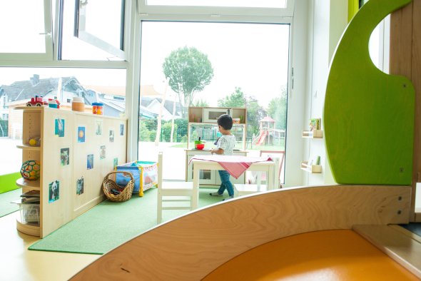 Kind spielt an Kinderküche in der Casa Feliz