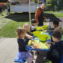 Kinder bereiten Essen zu im Hintergrund der Kochbus