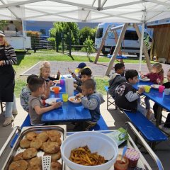 Kinder sitzen zusammen und essen ihre zubereitete Mahlzeit