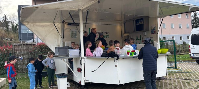 Kinder stehen im weißen Kochbus.