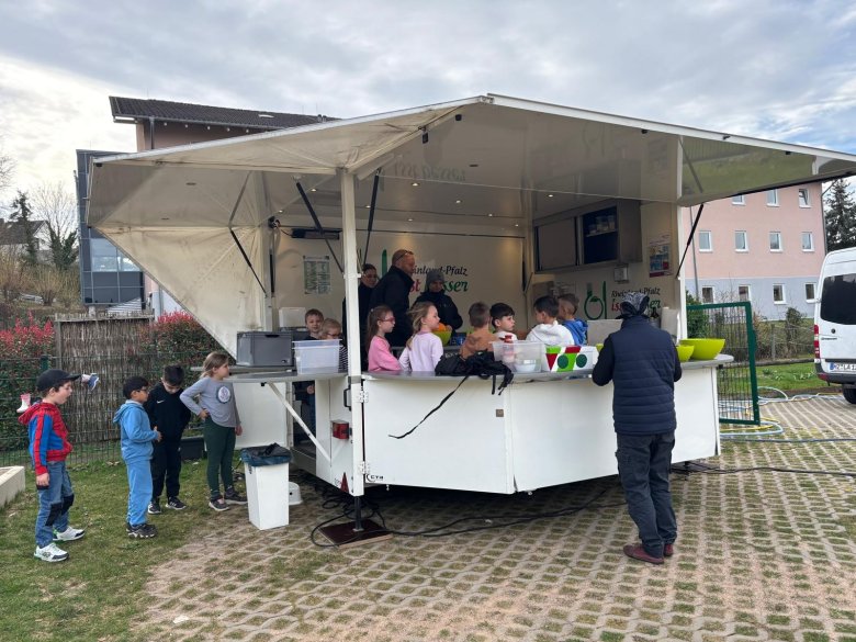 Kinder stehen im weißen Kochbus.